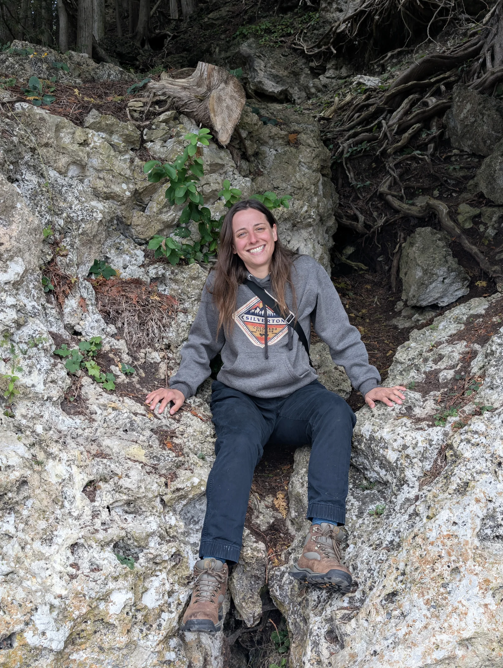 Abbey smiling in a rocky outdoor alcove